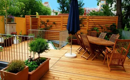 Eine moderne Holzterrasse mit Esstisch, Stühlen und Sonnenschirm. Stilvolle Terrassen aus Holz für gemütliche Stunden.