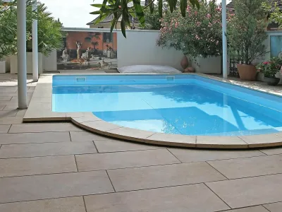 Großzügige Platten als elegante Poolumrandung inmitten einer mediterranen Gartengestaltung.
